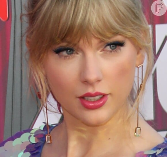 Taylor Swift arrasa no I Heart Radio com macaquinho metalizado e sandália com delalhe de borboleta