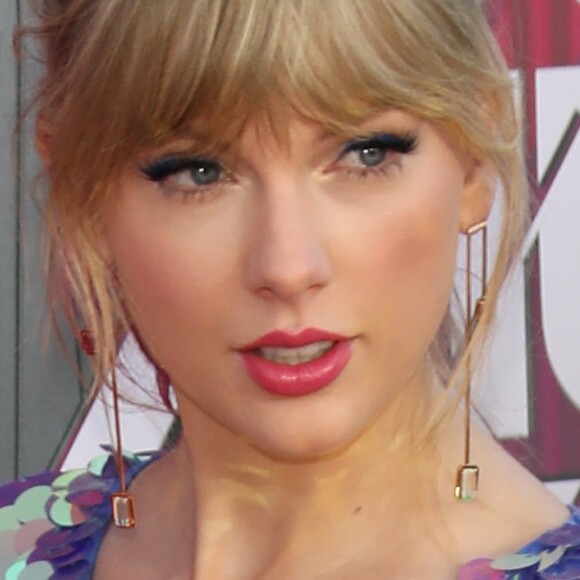 Taylor Swift arrasa no I Heart Radio com macaquinho metalizado e sandália com delalhe de borboleta