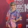 Taylor Swift vai com visual metalizado e sandália com detalhe de borboleta no I Heart Radio, em Los Angeles