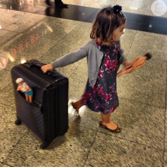 Olha a Olivia se achando uma mocinha e carregando uma mala com seus bonecos. Fofa!
