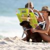 Juliana Paiva faz carinho em seu cachorro na praia