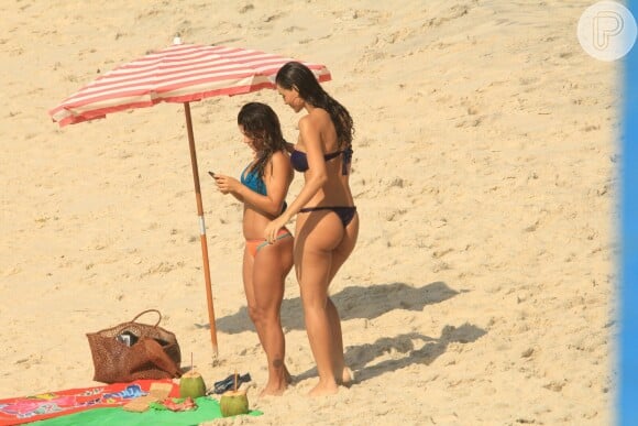 Débora Nascimento, de biquíni, grava na praia cenas da novela 'Verão 90' com a atriz Maria Carol