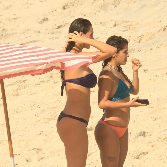 Na praia, Débora Nascimento exibe o corpo enxuto em cenas da novela 'Verão 90' com a colega de elenco Maria Carol