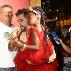 Com vestido vermelho Dolce & Gabbana, Títi chegou na festa no colo do pai, Bruno Gagliasso