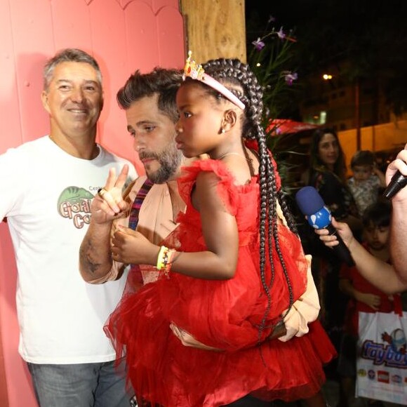 Com vestido vermelho Dolce & Gabbana, Títi chegou na festa no colo do pai, Bruno Gagliasso