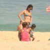 Carol Castro foi fotografada com a filha, Nina, em praia da Zona Sul do Rio