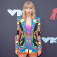 Taylor Swift apostou no blazer oversized como vestido + botas over the knee, tudo com brilho, da Versace