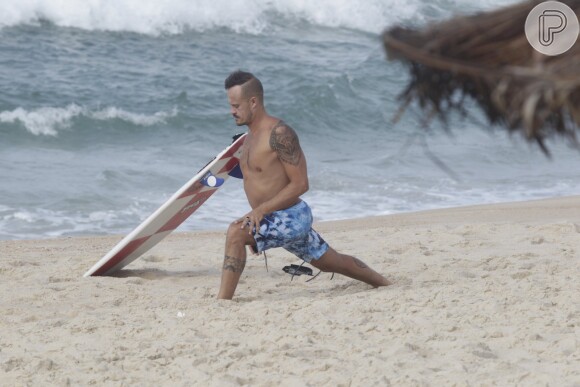 Paulinho Vilhena se exercita na areia antes de surfar