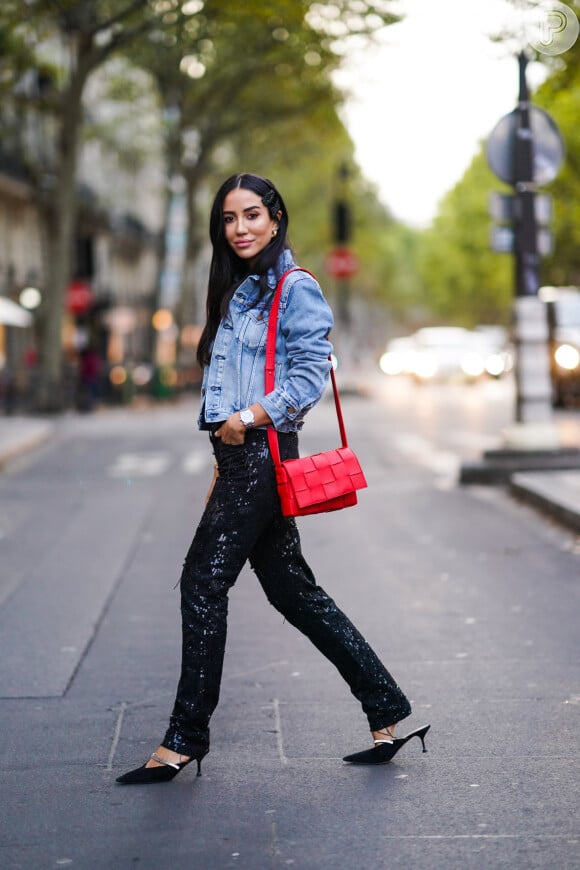 A calça com brilho compõe um look fashion com a jaqueta jeans durante o dia