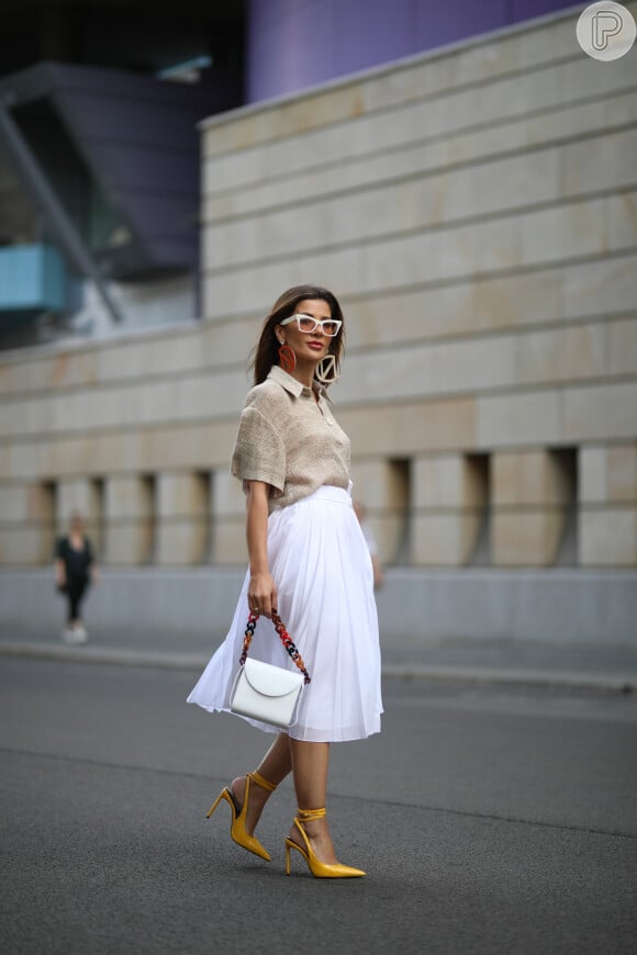 Moda verão 2020: camisa em linho é elegante e pode ser aliada à saia midi da cor branca em office look fresquinho