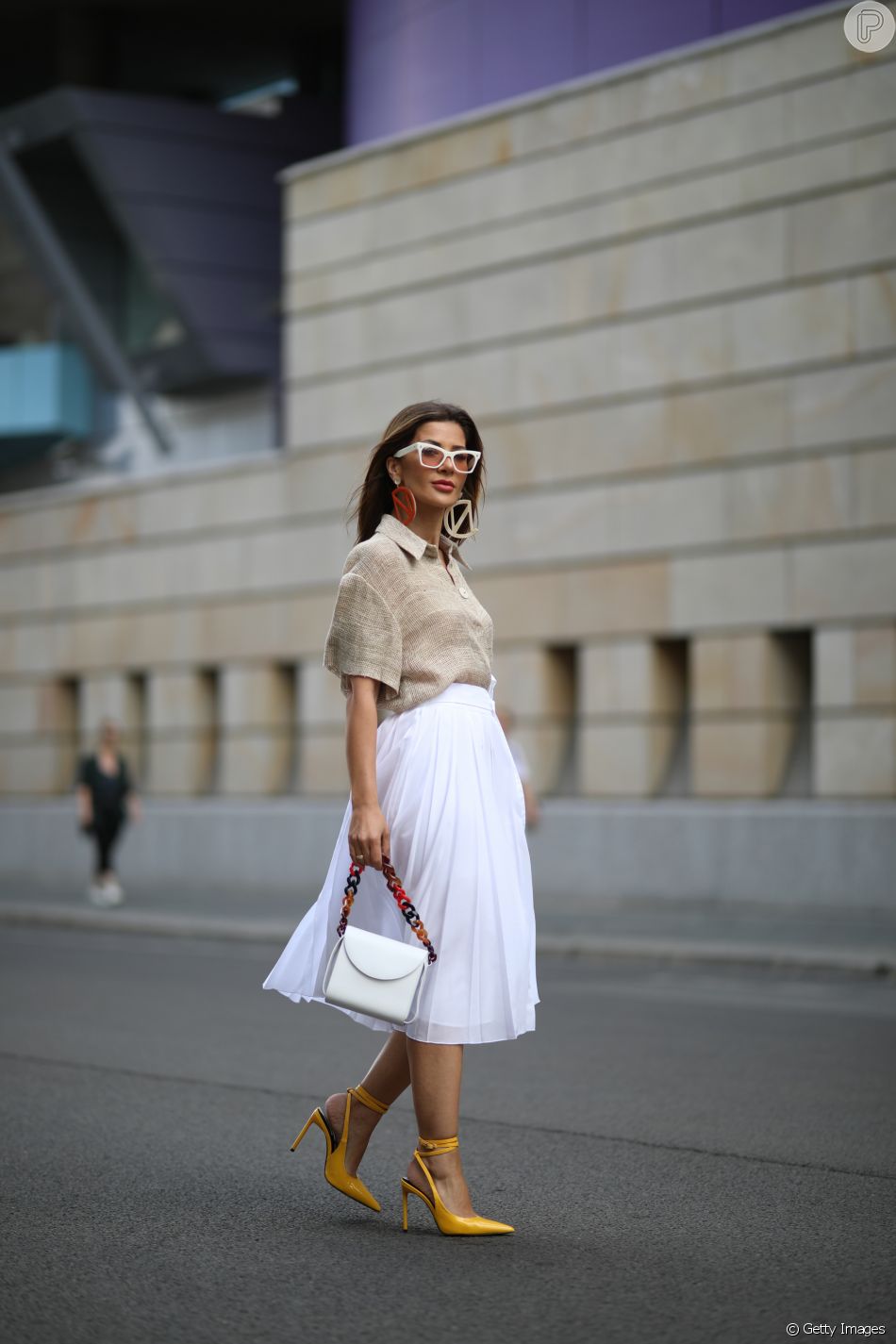 Moda verão 2020: camisa em linho é elegante e pode ser aliada à saia midi da cor branca em office look fresquinho
