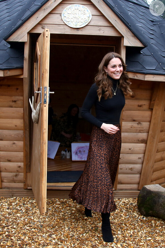 Kate Middleton deixou a saia de animal print à mostra após tirar o casaco de frio