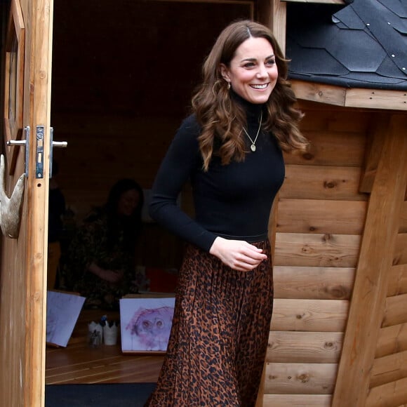 Kate Middleton deixou a saia de animal print à mostra após tirar o casaco de frio