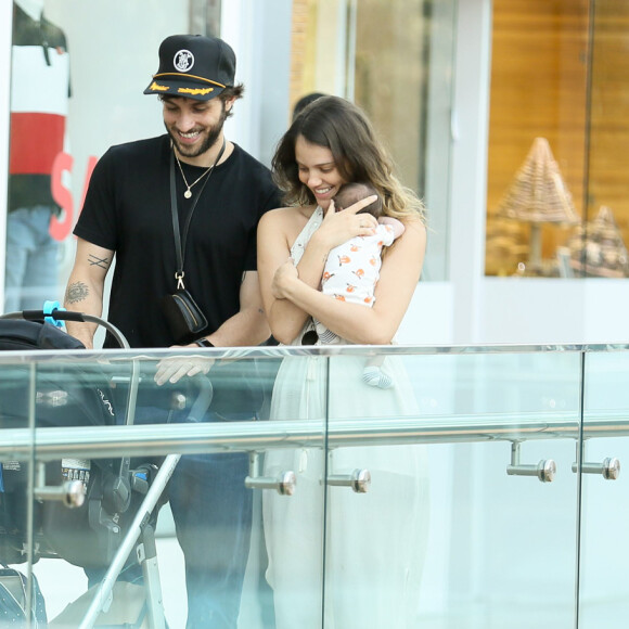 Laura Neiva aconchega a filha, Maria, de 1 mês, no colo durante passeio