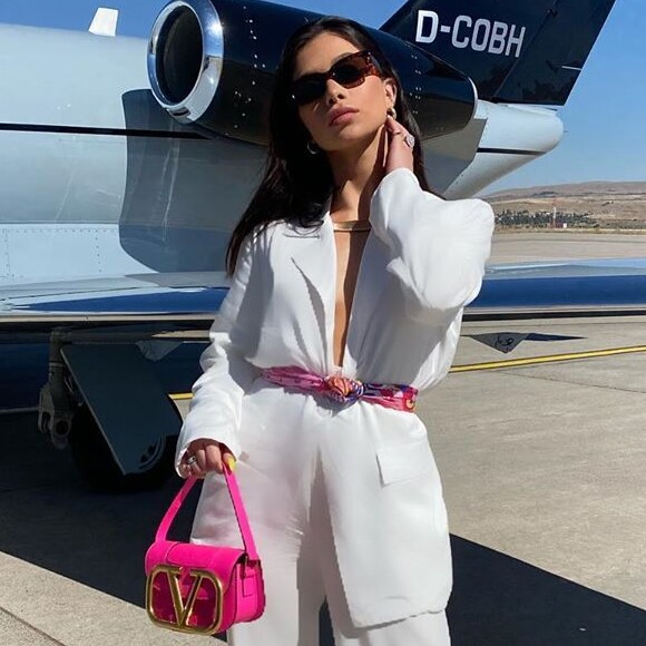 Flávia Pavanelli combina terninho branco com minibag rosa fluor