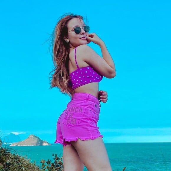 Larissa Manoela usa conjunto de top estampado e jeans com franjas na barra para ida à praia