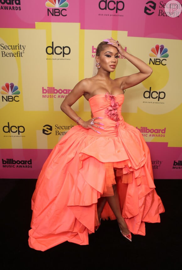 A rapper Saweetie usou um look de baile Giambattista Valli na cor salmão sem alças, que apresentava um corpete pregueado com flores rosa 3-D, no Billboard Music Awards 2021