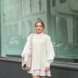 O colete off-white em tricot sobre o vestido curto e botas cano longo fica muito elegante