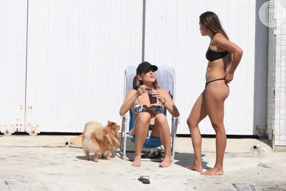 Mariana Goldfarb apostou em biquíni branco com estampa para dividir açaí com uma amiga na praia da Barra da Tijuca, onde nasceu e cresceu