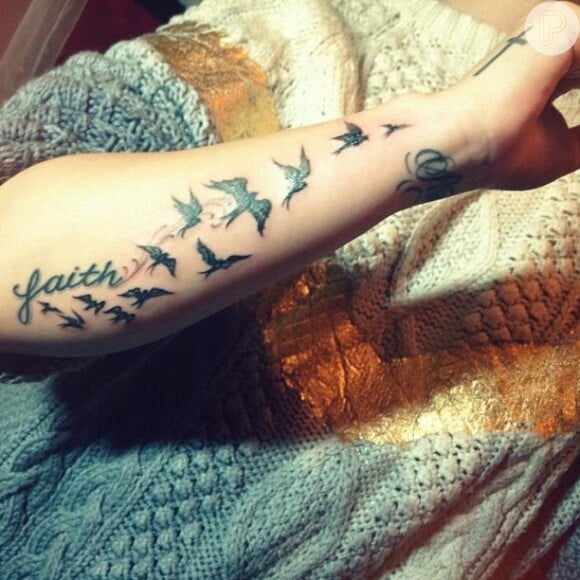 A cantora fez passáros perto de outra tatuagem, 'Faith' ('Fé', em português)