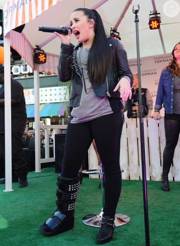Demi Lovato canta com a perna imobilizada