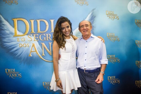 Com os fios cacheados, Anitta posa ao lado de Renato Aragão, na coletiva de imprensa do telefilme 'Didi e o Segredo dos Anjos'