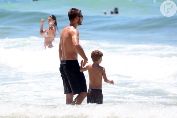 Rodrigo Hilbert leva um dos filhos para tomar banho de mar