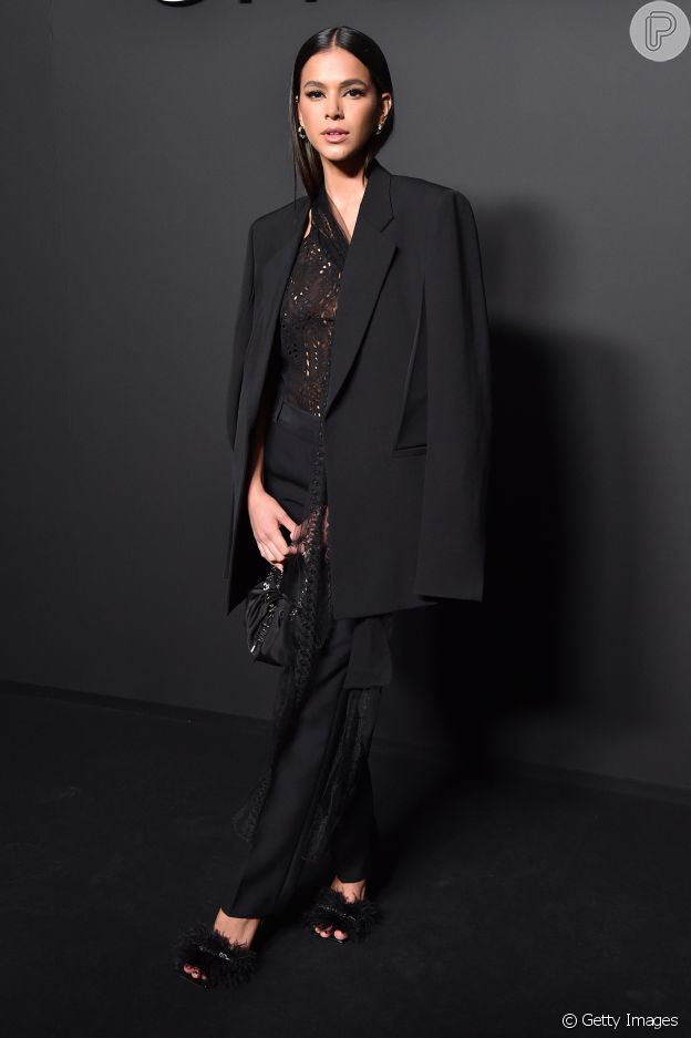 A atriz Bruna Marquezine usou look all black com sandálias de plumas nos pés para desfile da Givenchy
