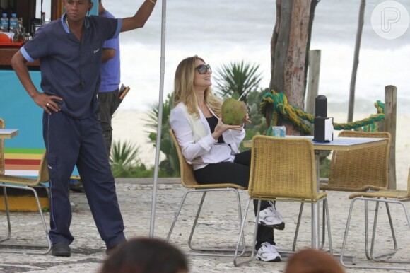 Antonia (Letícia Spiller) toma água de coco na orla da praia em cena de 'Salve Jorge'