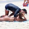 Thammy Miranda é fotografada em dia de praia ao lado da namorada, usando sunga, em  janeiro de 2015, um mês após a retirada dos seios