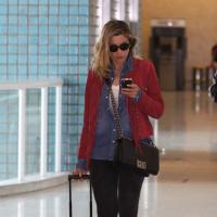 Flávia Alessandra caminha distraída e com visual de inverno em aeroporto do Rio