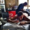 O jogador, que passa as festas de final de ano no Brasil, se distrai com o celular enquanto é tatuado por Filipe Genesi