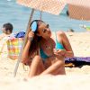 Yasmin Brunet penteia os cabelos enquanto toma sol na praia de Ipanema