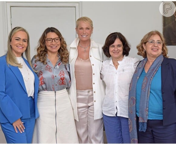 A saia midi em off-white foi usada com camisa social estampada por Janja em encontro com Xuxa Meneghel
