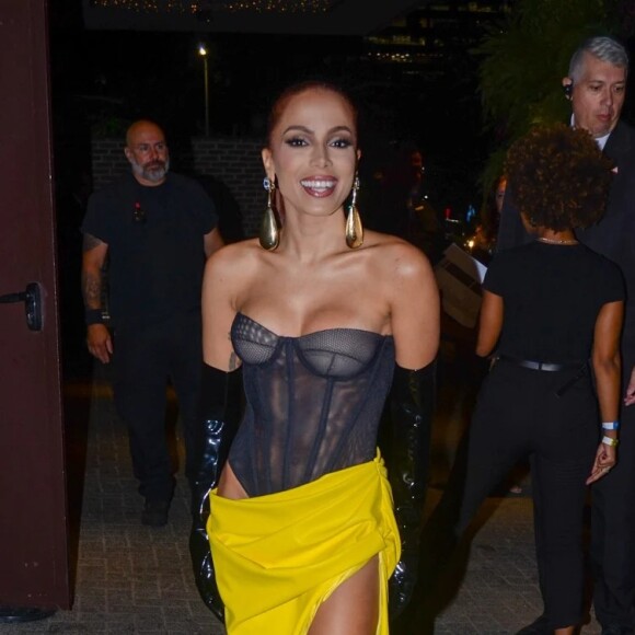 Anitta apostou em um body preto transparente e uma saia amarela fendada para o primeiro dia de sua festa em São Paulo