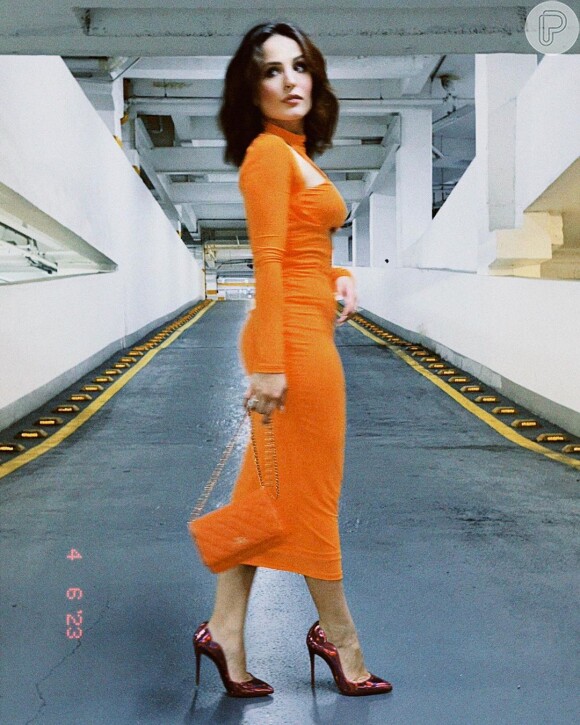 Vestido laranja midi de Larissa Manoela foi combinado com bolsa grifada da mesma cor pela atriz