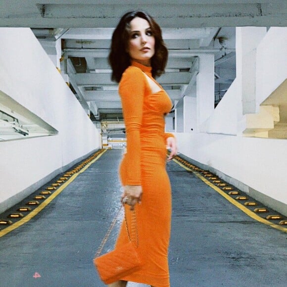 Vestido laranja midi de Larissa Manoela foi combinado com bolsa grifada da mesma cor pela atriz