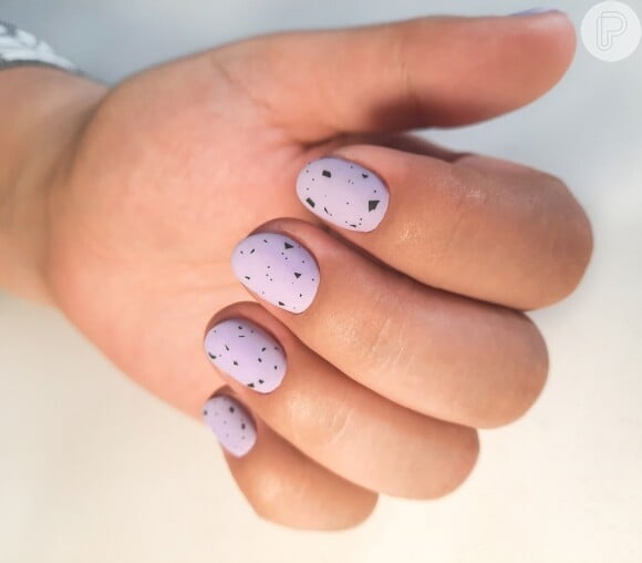 Unhas curtinhas com esmalte lilás e detalhes em preto: essa nail art é minimalista e cheia de estilo