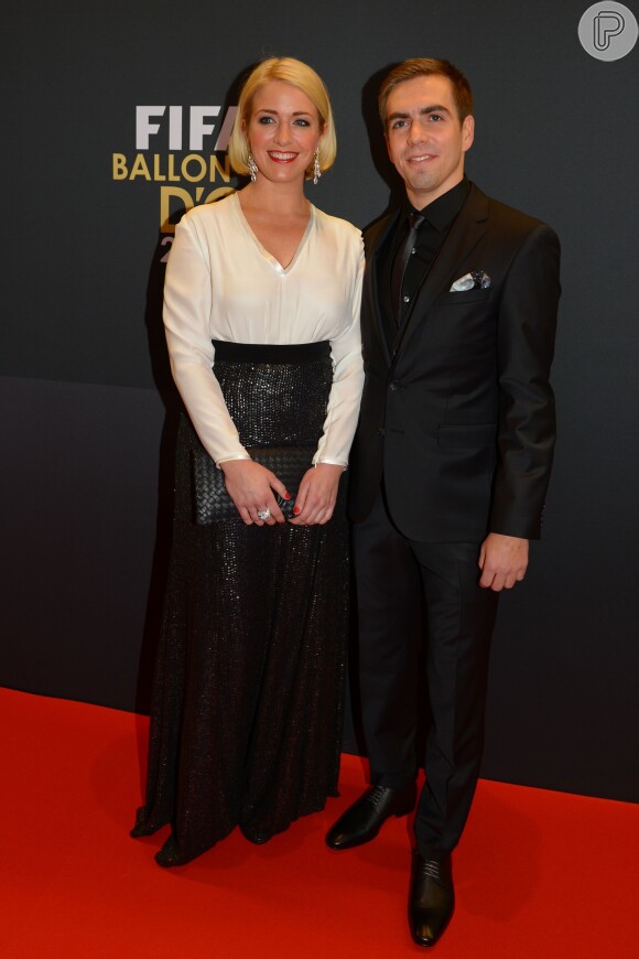 Philipp Lahm e sua mulher, Claudia Lahm, que escolheu uma camisa branca e uma saia longa preta brilhosa