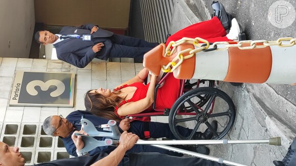 Fátima Bernardes foi flagrada chegando à Globo neste sábado (11) usando cadeira de rodas