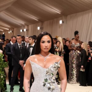 Demi Lovato impressionou com um vestido prateado com detalhes florais enquanto posava no tapete vermelho