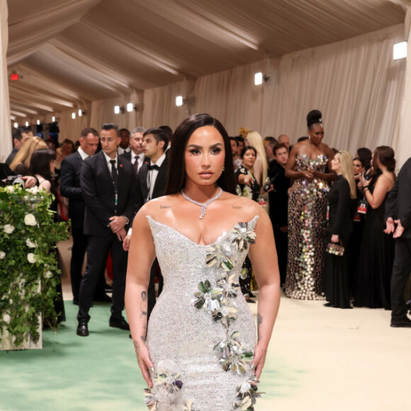 Demi Lovato impressionou com um vestido prateado com detalhes florais enquanto posava no tapete vermelho