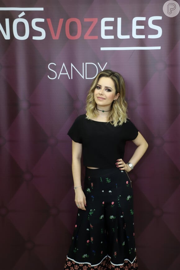 Sandy alia peças pretas com estampas simples em raras ocasiões