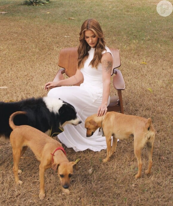 Na publicação, Andressa Suita aparece com um vestido branco, fazendo poses e interagindo com doguinhos