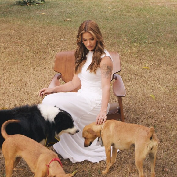 Na publicação, Andressa Suita aparece com um vestido branco, fazendo poses e interagindo com doguinhos