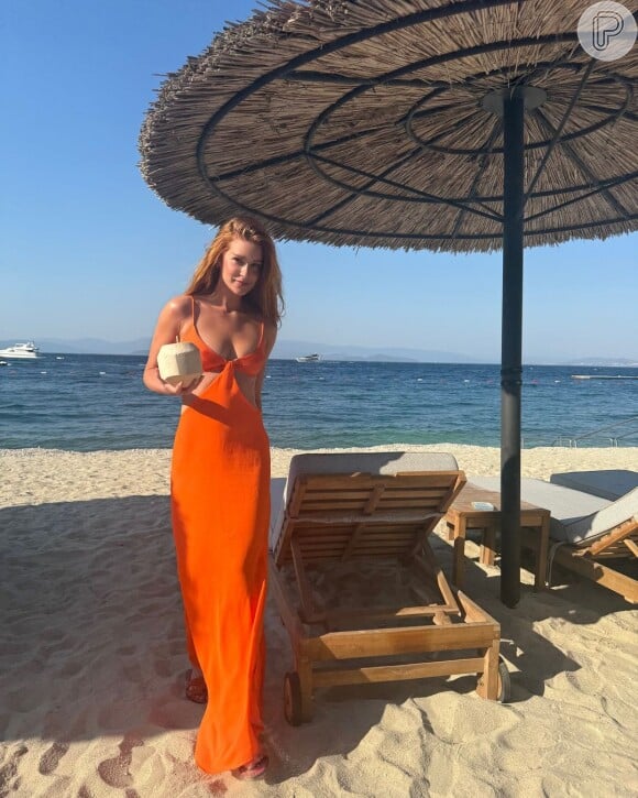 O outro vestido que Marina Ruy Barbosa usou durante a viagem para a Itália foi laranja, com recortes nas laterais, e top de alcinhas reguláveis, também da sua marca Ginger.