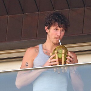 Hopedado no Hotel Fasano, Shawn Mendes foi flagrado por paparazzo tomando água de coco e comendo banana