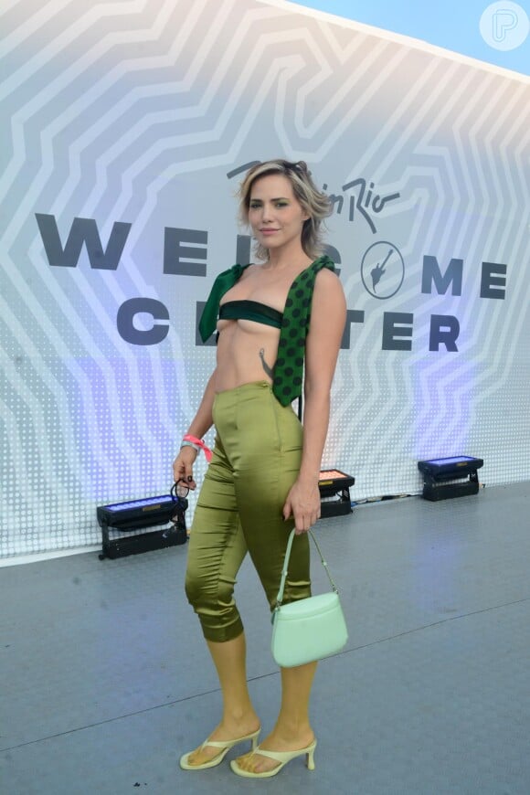 Letícia Colin usou um look verde com top feito de gravatas, calça capri em cetim, e bolsa grifada da Prada para curtir o Rock in Rio.