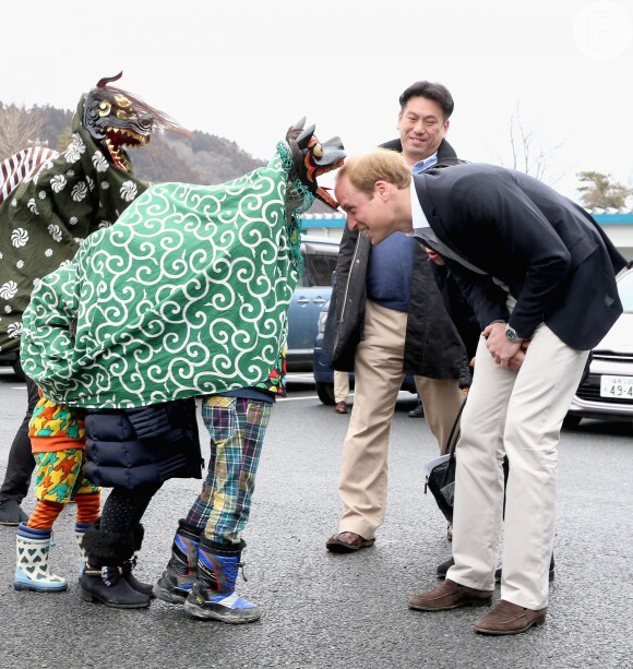 Príncipe William brinca com crianças em parque infantil
