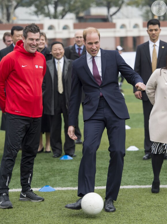 Príncipe William joga futebol de terno e gravato em visita à China